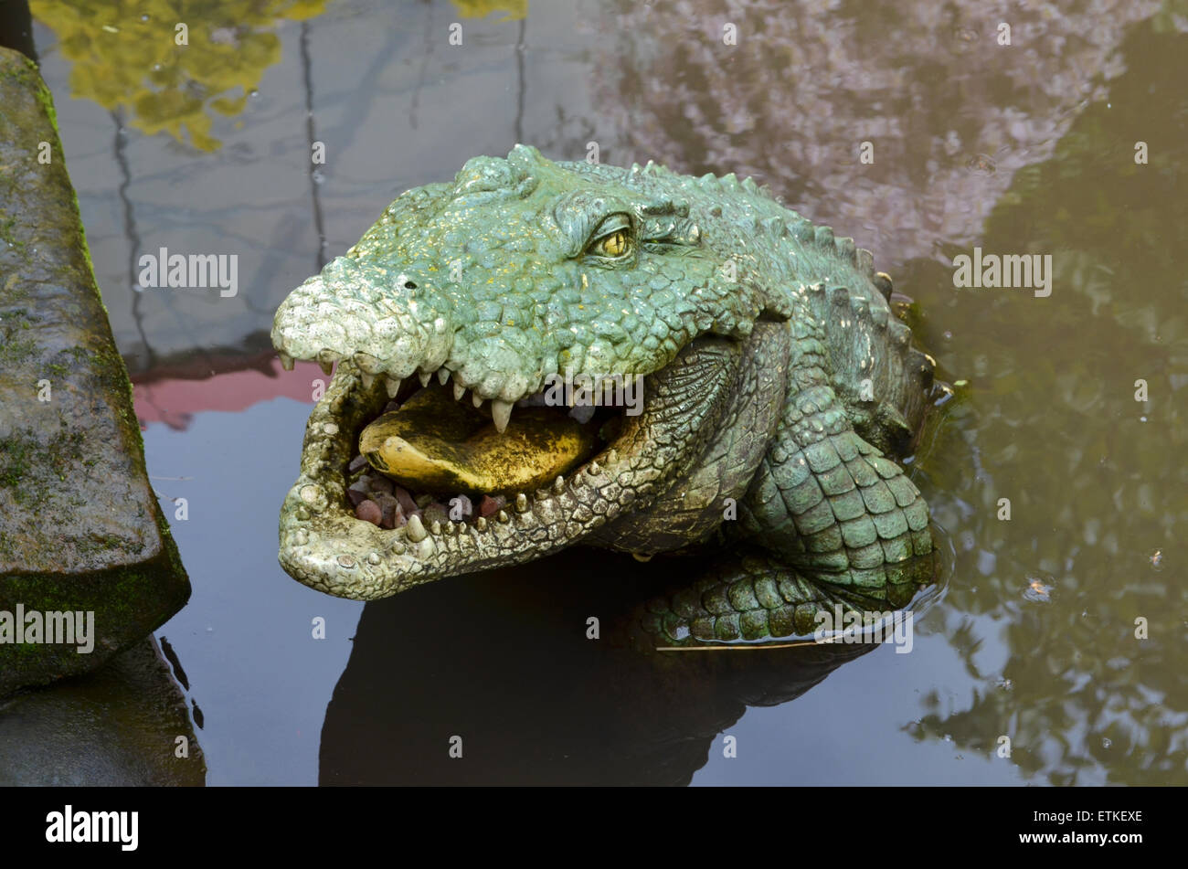 Fiberglas-Krokodil in einem Teich, Snap happy Stockfoto