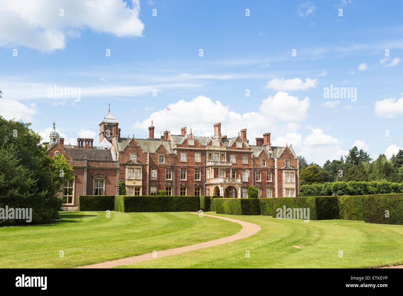 Anzeigen von Sandringham House, ein Landhaus, das Norfolk Rückzug der Königin in East Anglia, im Sommer mit einem blauen Himmel und flauschigen weissen Wolken Stockfoto