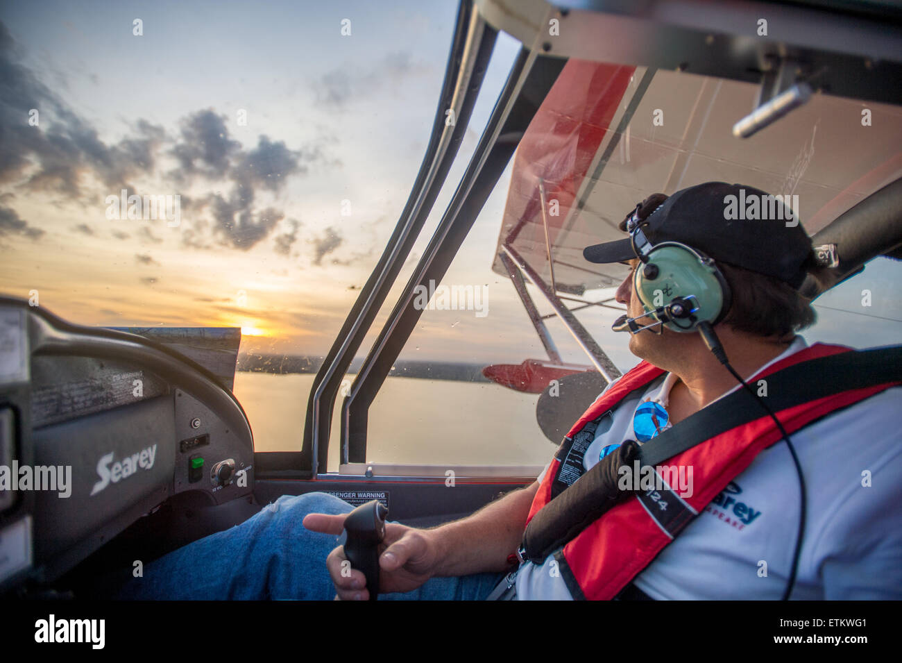 Männliche Pilot, Blick auf den Sonnenuntergang während des Fluges Wasserflugzeug im Südosten der USA Stockfoto