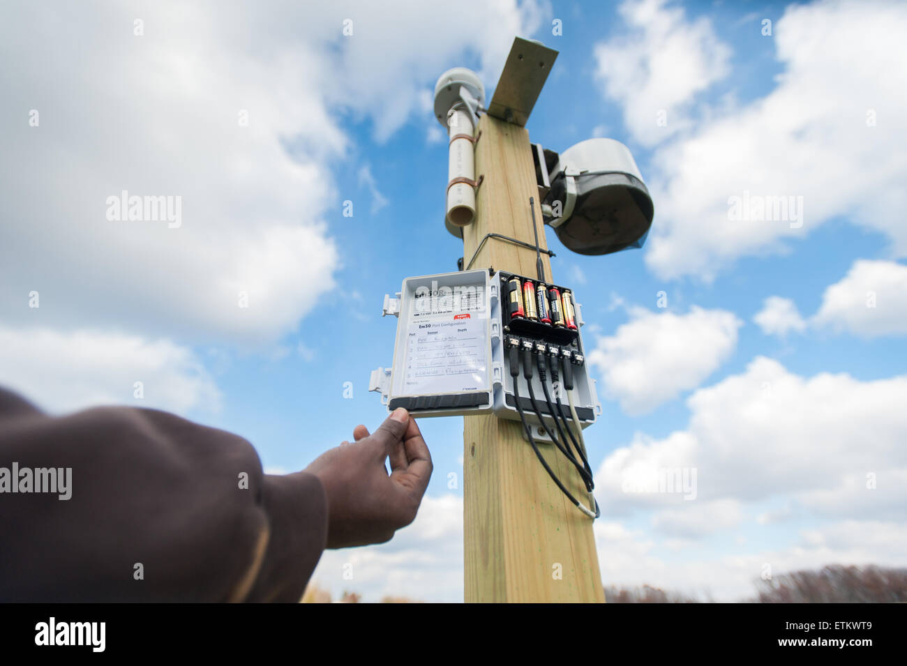 African American Hand, die Tür zu Feuchtigkeit Sensor Unit bei einem Obstgarten im Montgomery County, Maryland, USA Stockfoto