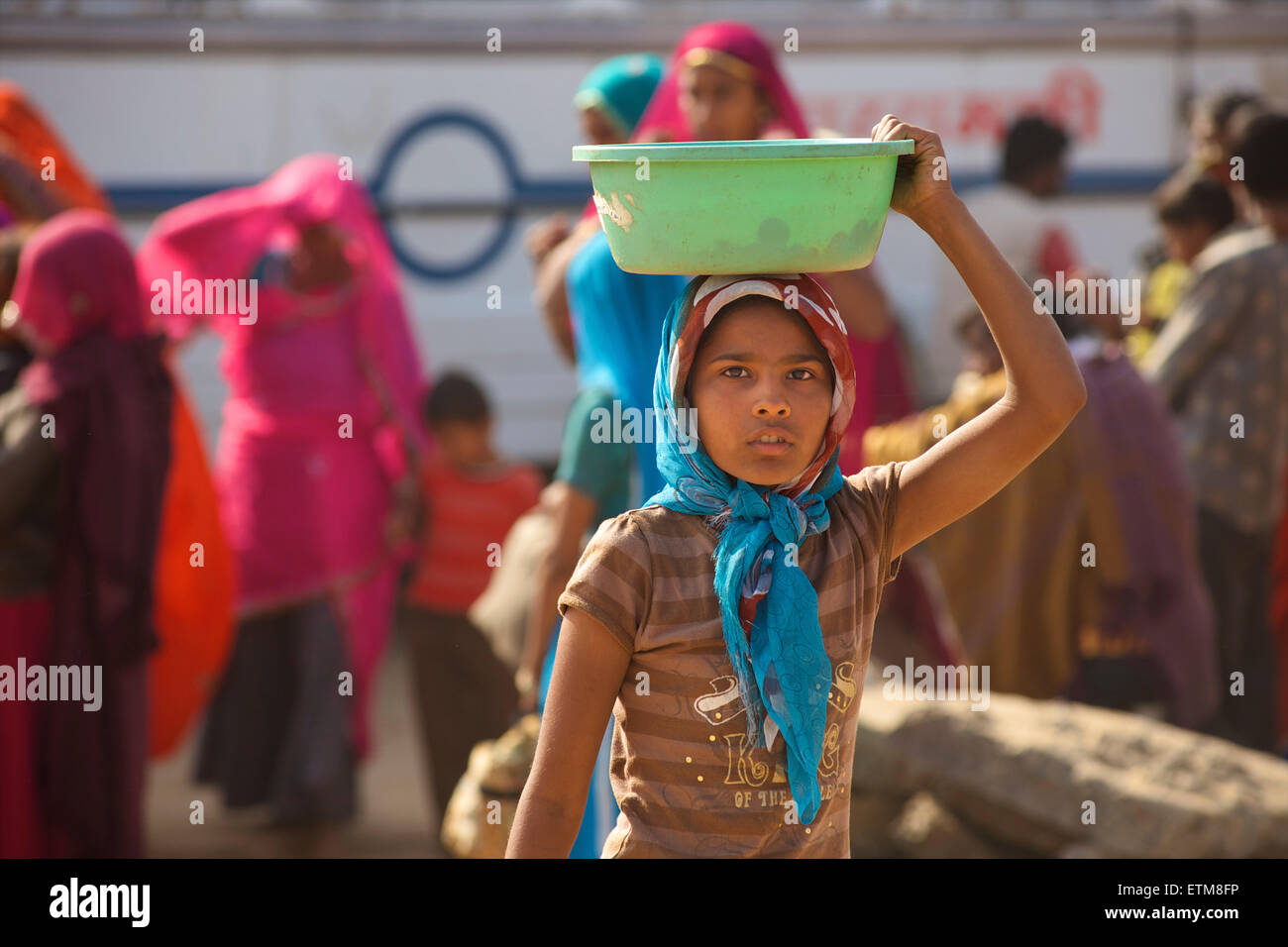 Indische Mädchen sammeln Kamel Dung in einer grünen Schale. Pushkar Camel Fair, Rajasthan, Indien Stockfoto