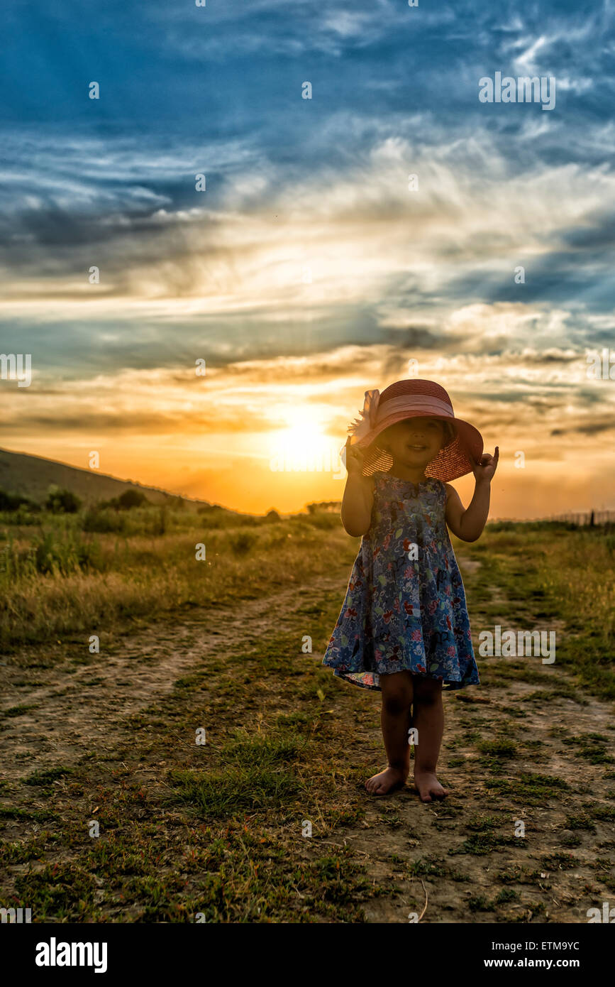 Schöne Mädchen mit Hut bei Sonnenuntergang Stockfoto