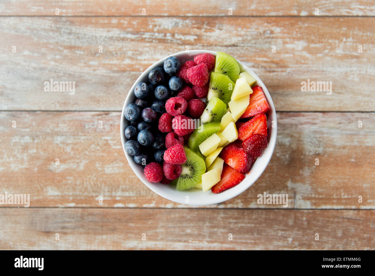 Nahaufnahme von Früchten und Beeren in Schüssel auf Tisch Stockfoto
