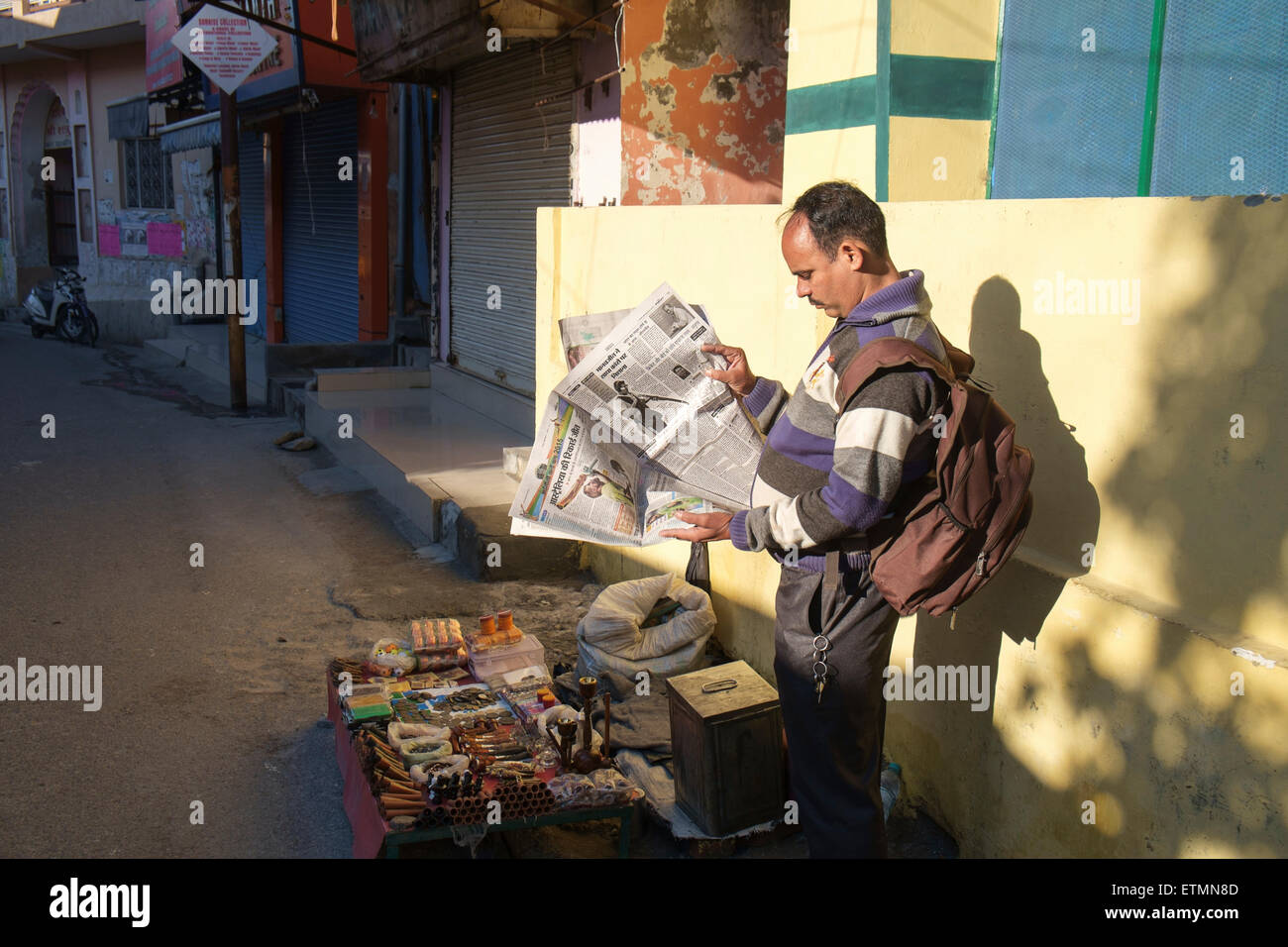 Mann liest Zeitung auf der Straße von Rishikesh. Stockfoto