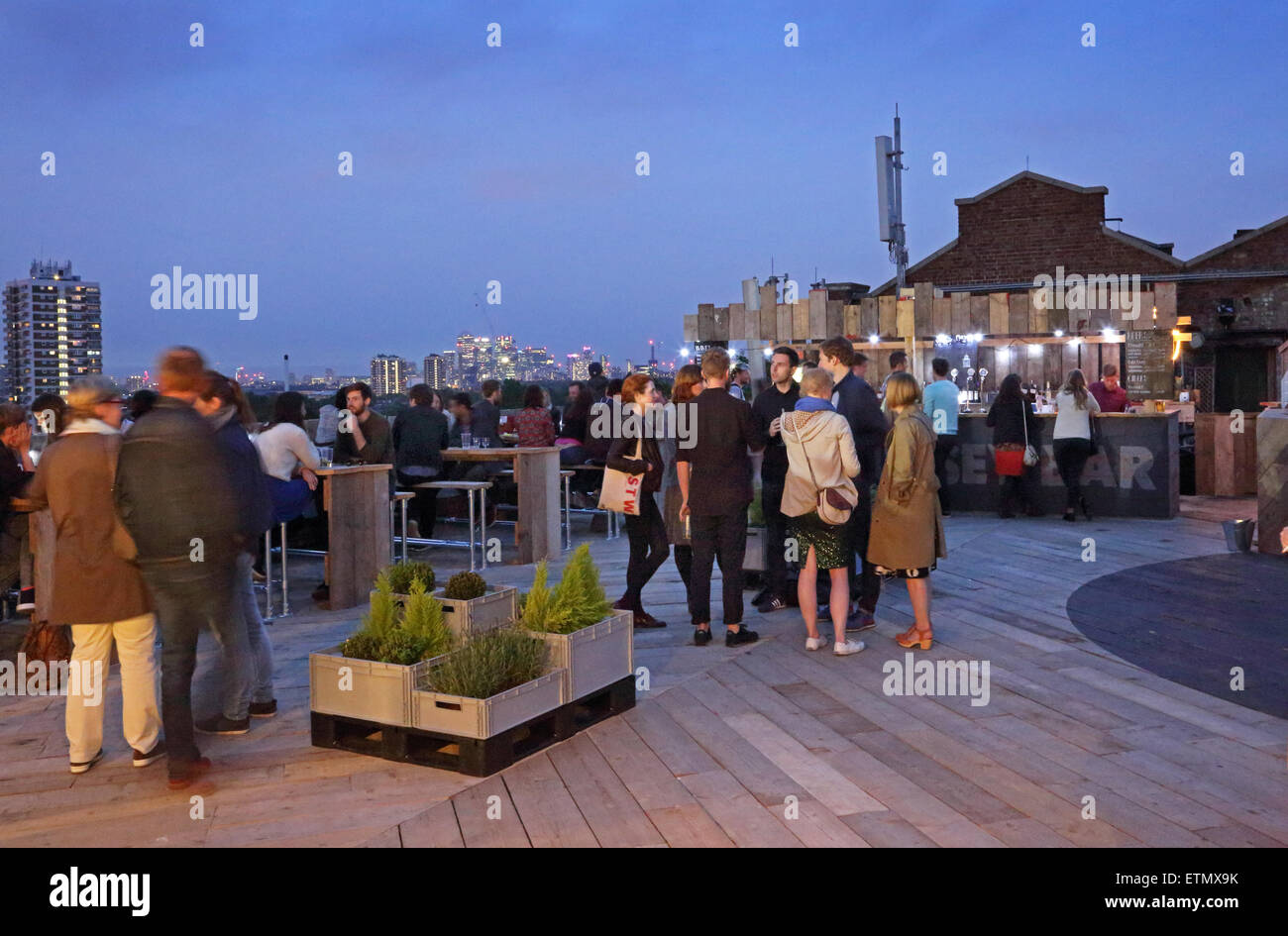 Kunden, die trinken an der Bar auf dem Dach Peckhams Bussey Building - einer umgebauten Fabrik beherbergt heute Künstler und Veranstaltungsorte Stockfoto