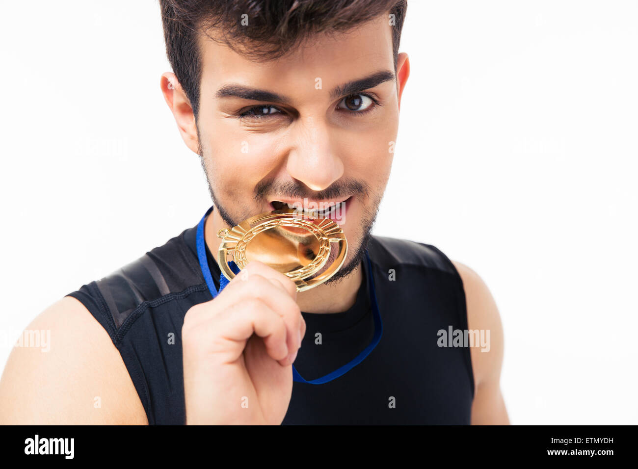 Sport-Mann beißt Medaille isoliert auf einem weißen Hintergrund. Blick in die Kamera Stockfoto