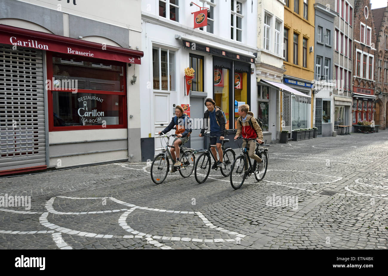 Drei Kinder, die Radfahren zur Schule am Sint-Amandsstraat in Brügge, Belgien Stockfoto