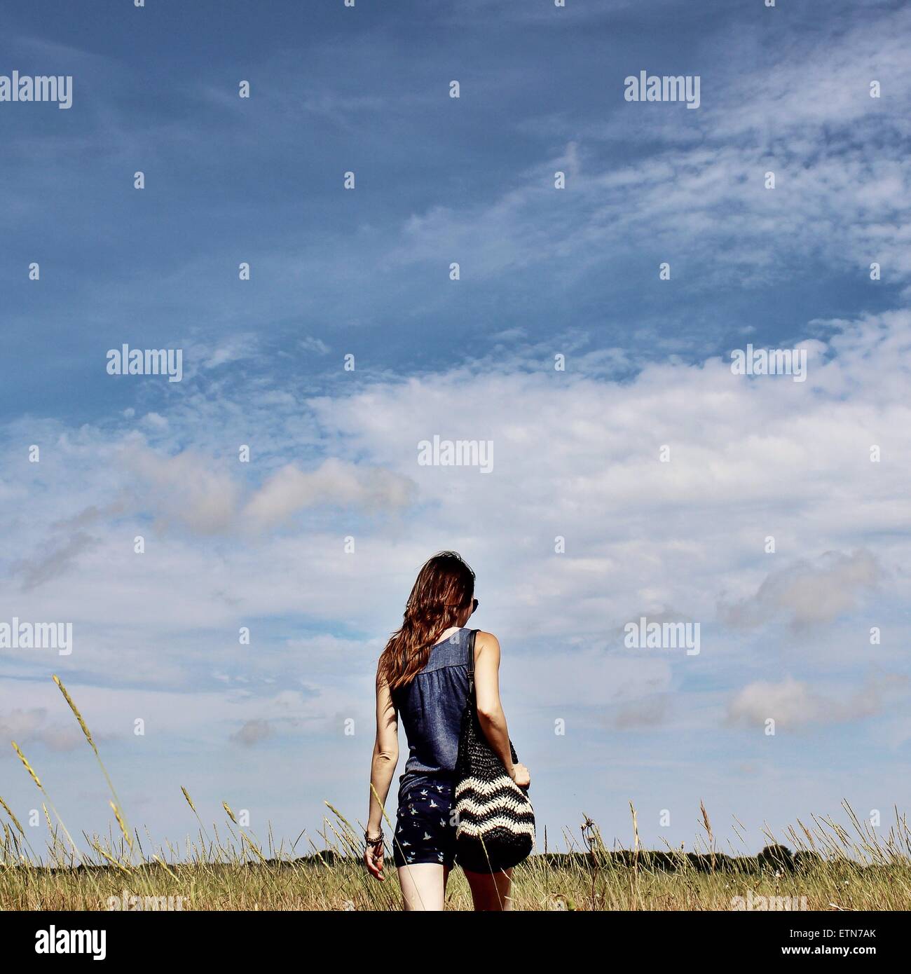 Rückansicht eines Mädchens zu Fuß in ein Feld Stockfoto