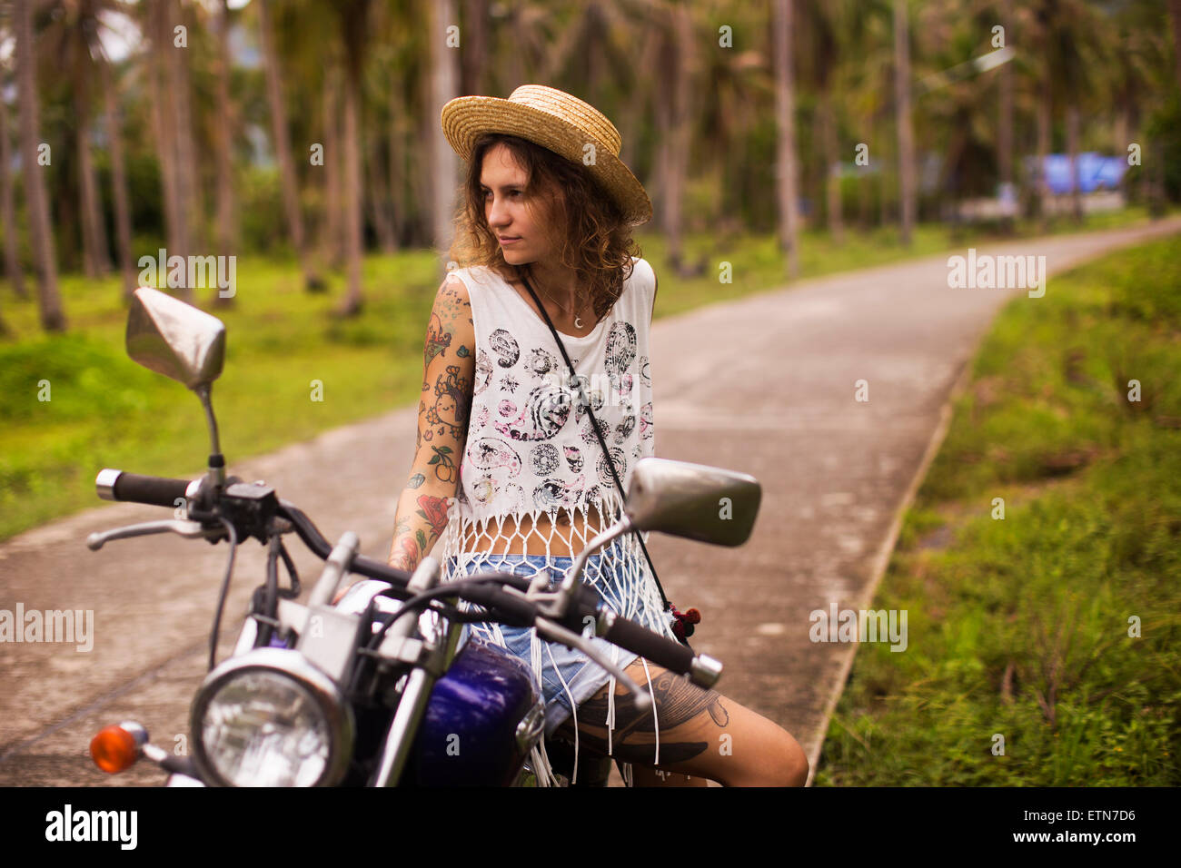 Kantigen tätowierte Frau sitzt auf einem Motorrad Stockfoto