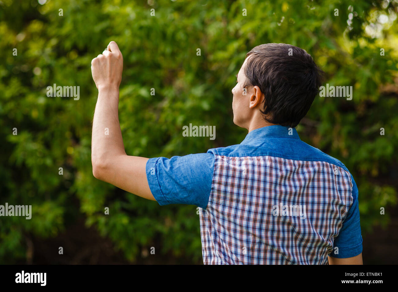 Mann, die Hand in der Luft zurück zu schreiben, auf einem grünen Hintergrund Straße t Stockfoto