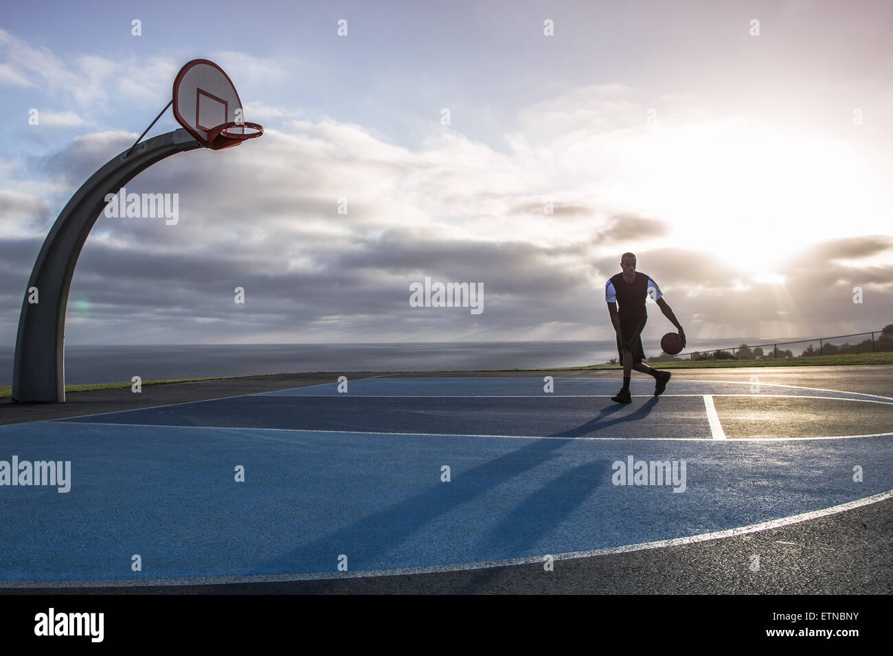 Junger Mann spielen Basketball in einem Park, Los Angeles, Kalifornien, USA Stockfoto