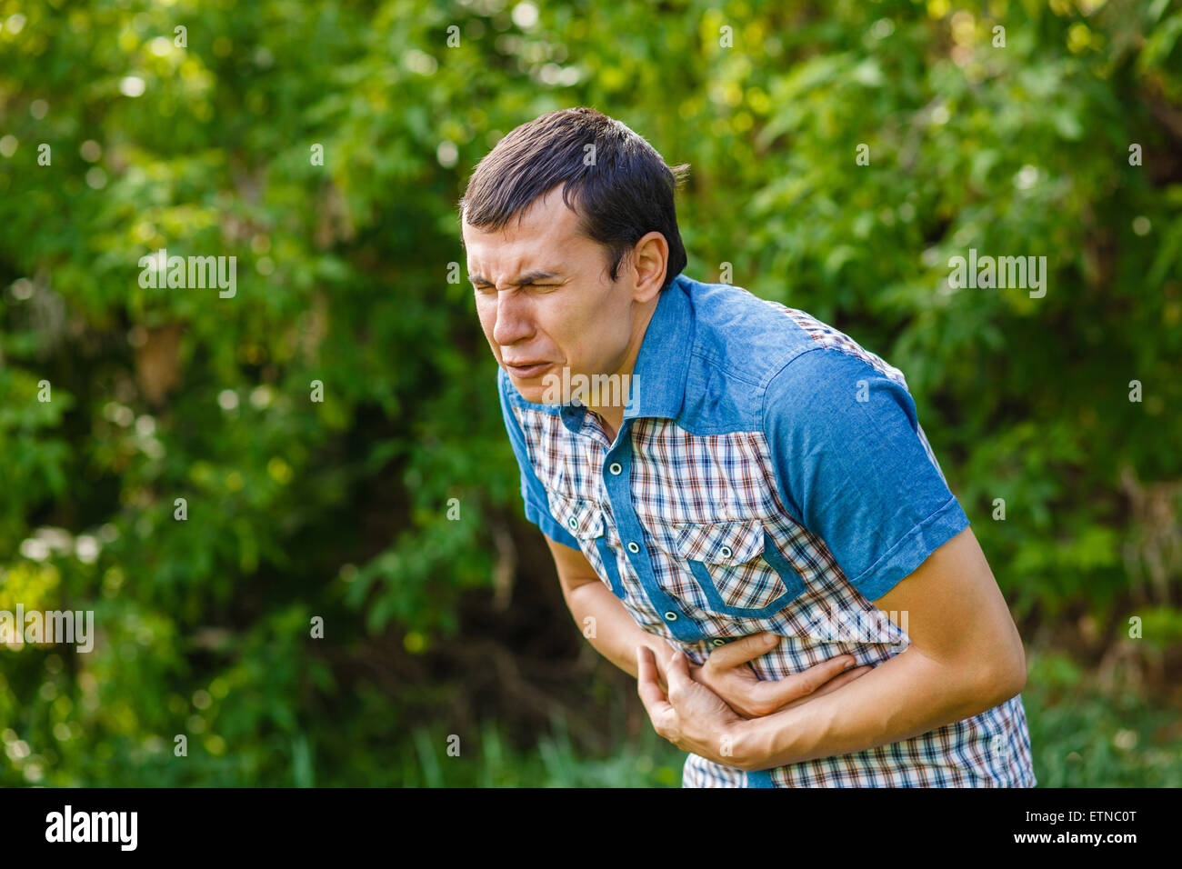 Mann auf der Straße Bauchschmerzen auf grünem Grund verlässt su Stockfoto
