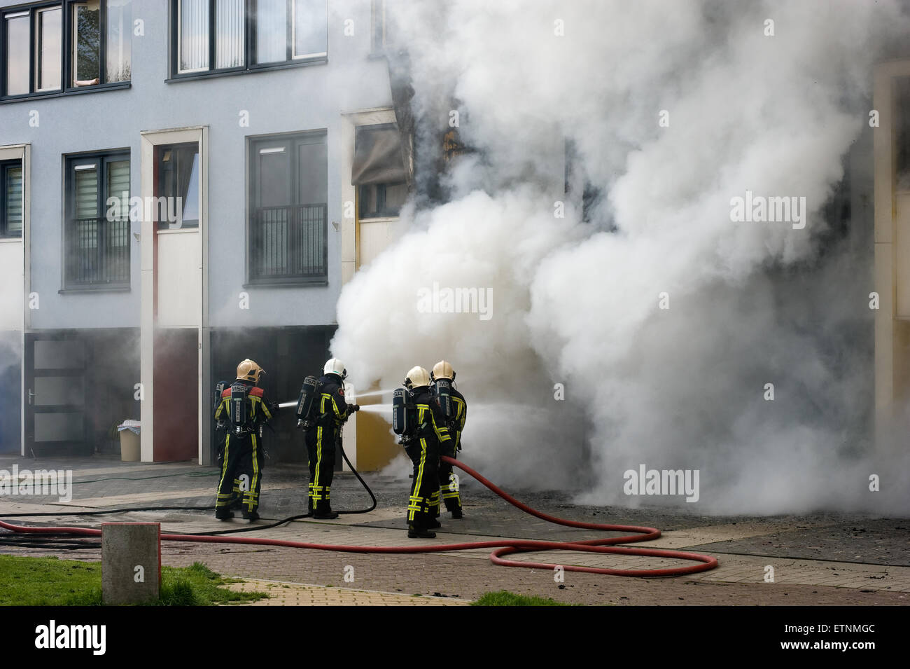 Feuerwehrleute sind beschäftigt, um ein Feuer in einem Haus löschen Stockfoto