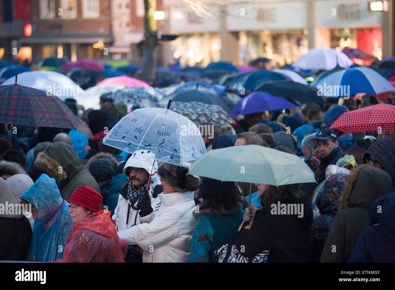 ENSCHEDE, Niederlande - 2. April 2015: Menschen mit des Regenschirmes warten im Regen an einem kalten und regnerischen Tag im Frühling Stockfoto