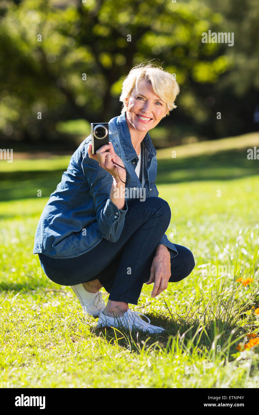 fröhliche senior Frau hält eine Kamera im freien Stockfoto