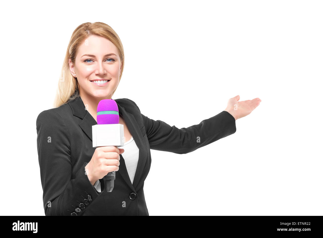 Attraktive blonde TV-Moderatorin hält ein Mikrofon und Punkte zu einem Objekt. Isoliert auf weißem Hintergrund. Stockfoto