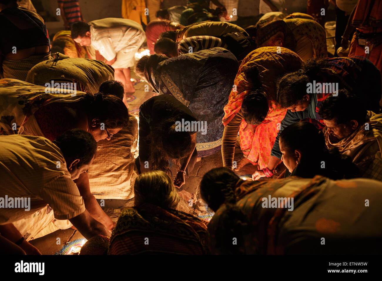 Eine Gruppe von Süd indische Frauen pilgern Leuchten Kerzen in der Nacht bei Raja Ghat in Varanasi, Indien. Stockfoto