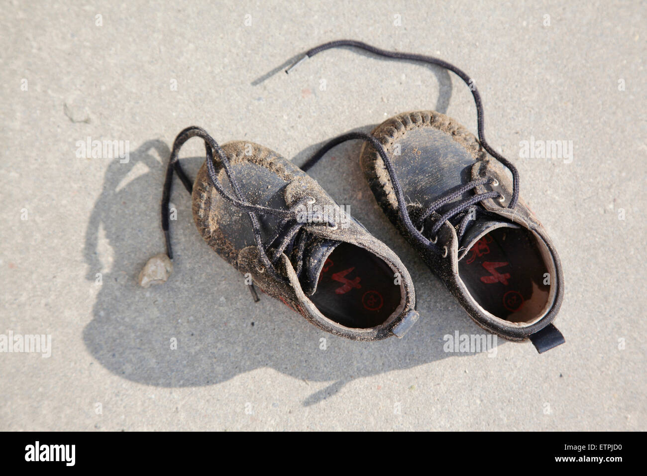 Kleine Babyschuhe mit Sand bedeckt Stockfoto