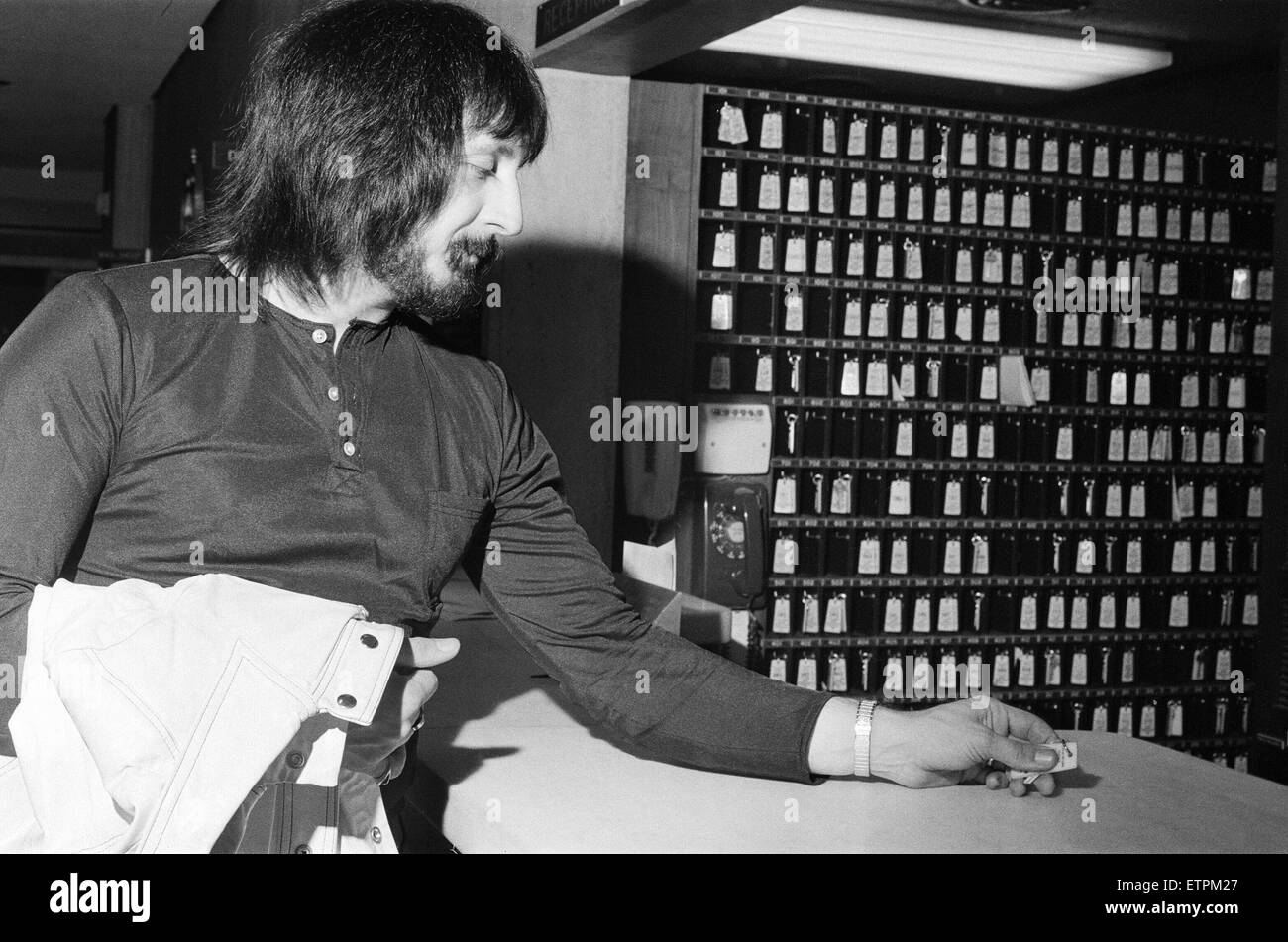 Mitglieder der Rockband The Who. Bassist John Entwistle Hände in seinen Zimmerschlüssel an der Rezeption. 8. Dezember 1973. Stockfoto