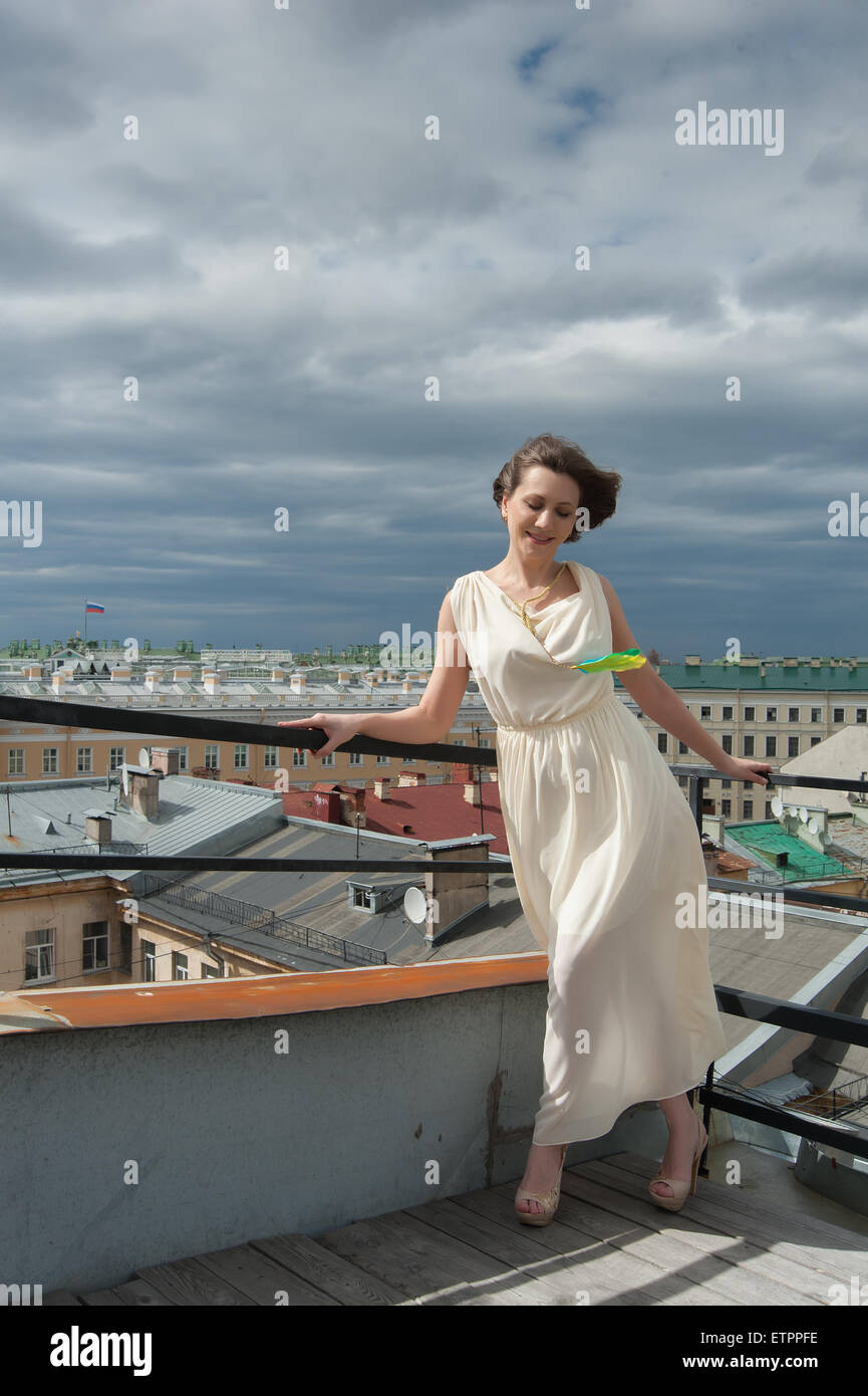 Wunderschöne Frau lächelnd in den Wind auf dem Dach Stockfoto