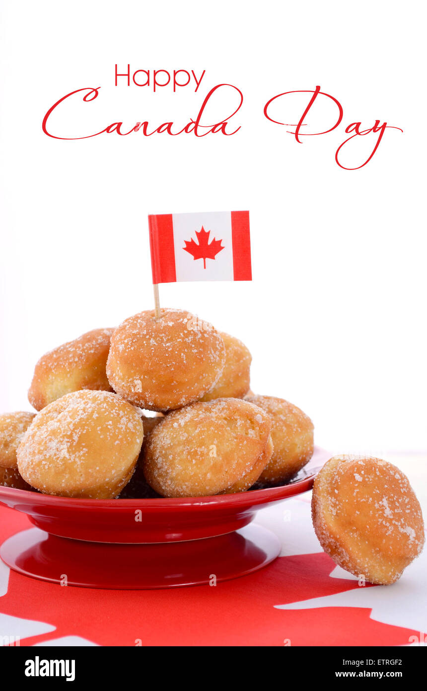 Stapel von Donut Löcher an roten Platte auf kanadische Maple Leaf Flagge für Happy Canada Day Feier, Party. Stockfoto