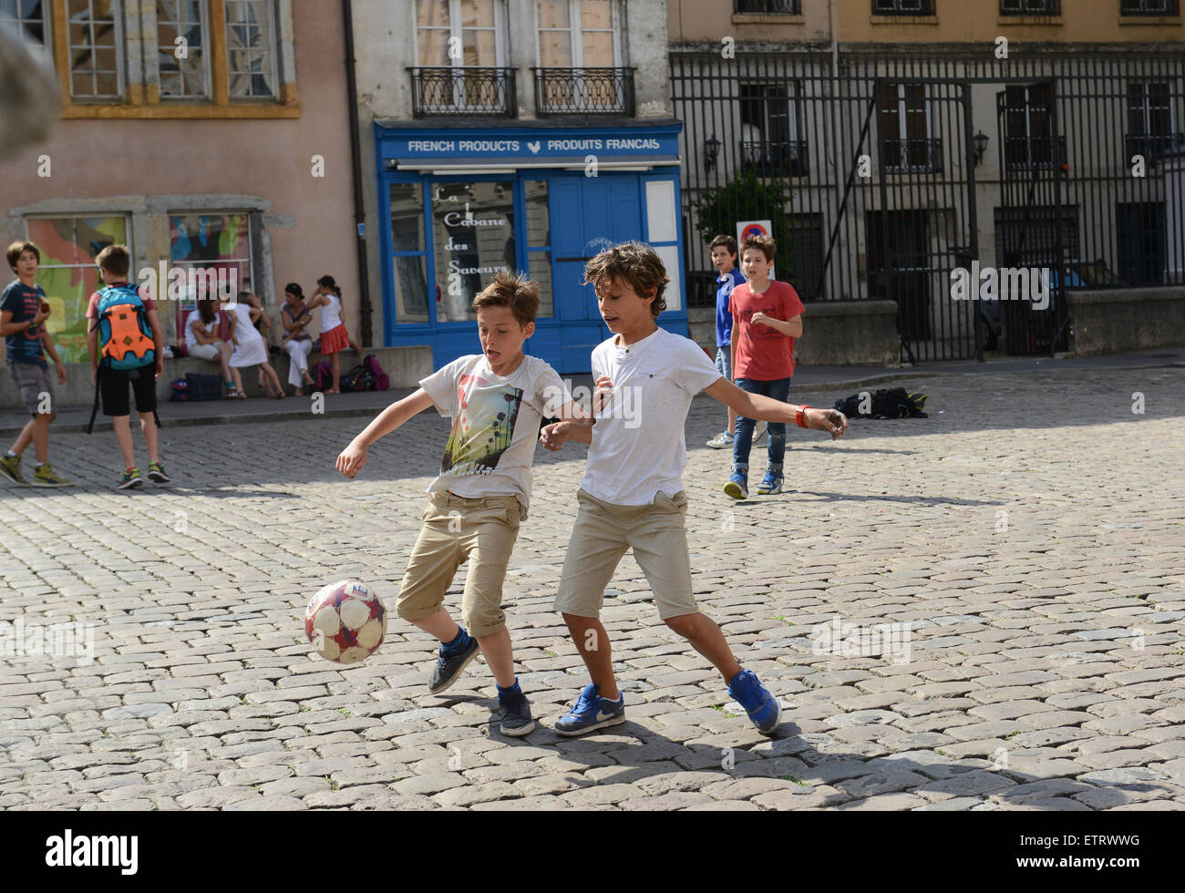 Kinder Jungen Fußball spielen auf gepflasterten Straße in Lyon Frankreich Europa Stockfoto