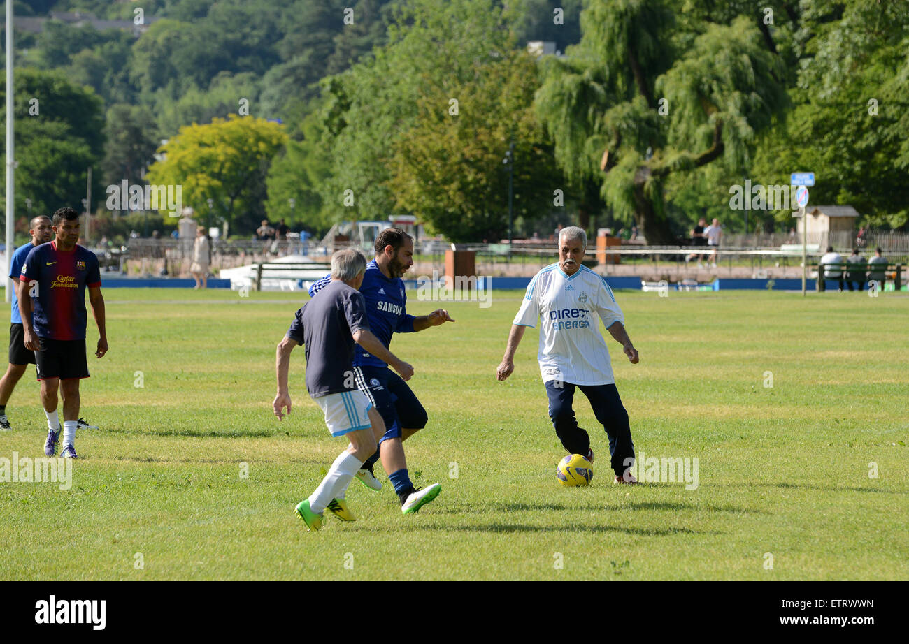 Amateurfußballspieler Männer jeden Alters spielen ein improvisiertes Spiel im öffentlichen Park von Annecy in Frankreich. Männer spielen Fußball im Park Stockfoto