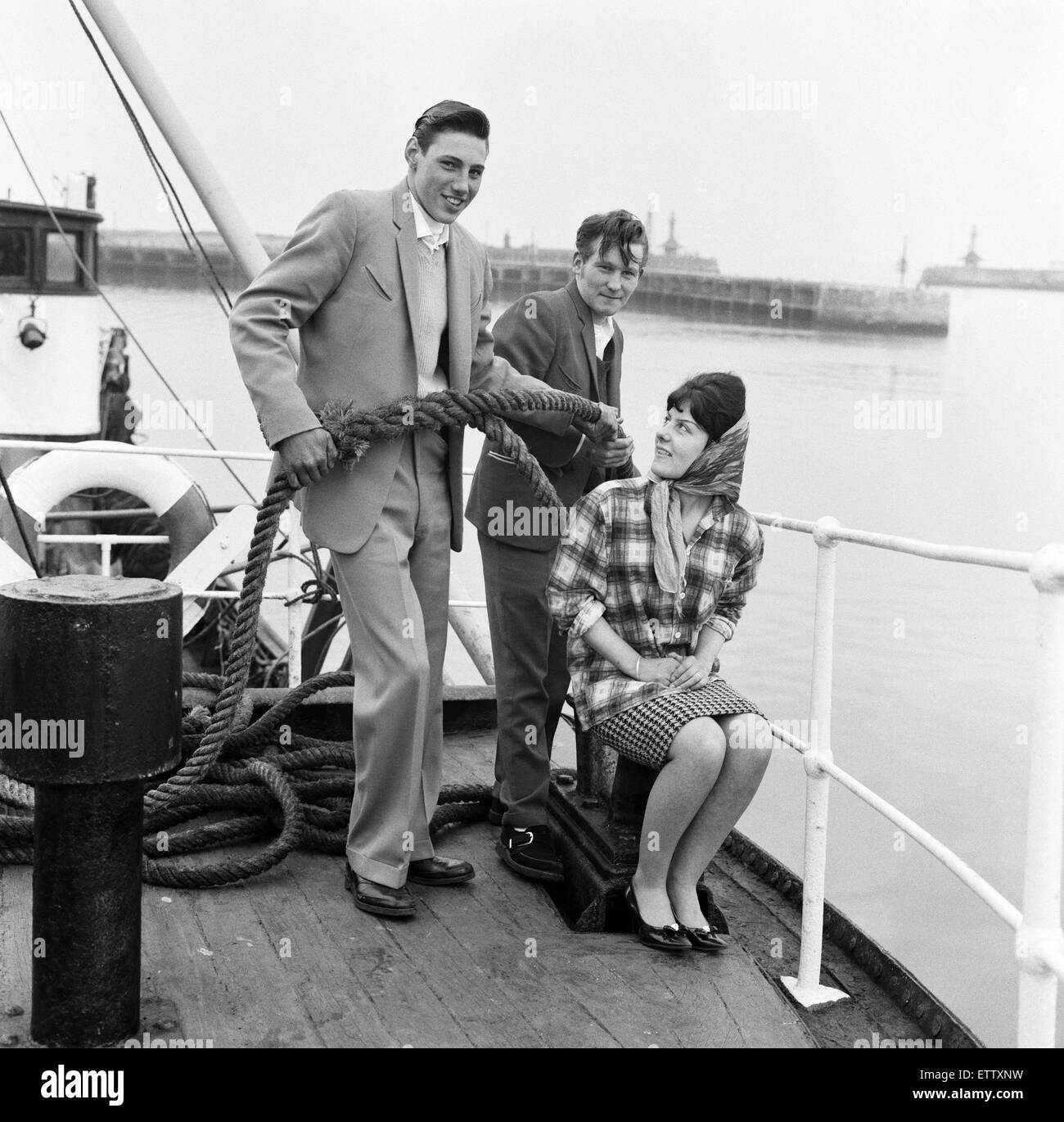 Ray Winney, 16, und Tony Scrivens, 16, mit Gloria Rittern, 17. auf dem Boot "Tobago". "Dockside Dandys" bei Lowestoft, Suffolk. 16. Mai 1962. Stockfoto