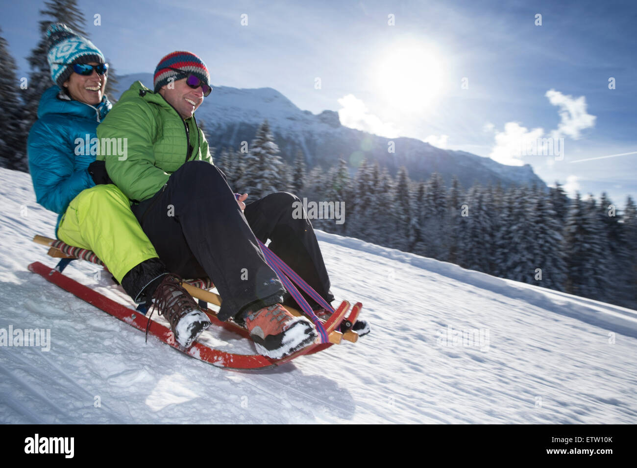 Deutschland, Bayern, Inzell, Paare, die Spaß auf einem Schlitten im tief verschneiten Landschaft Stockfoto