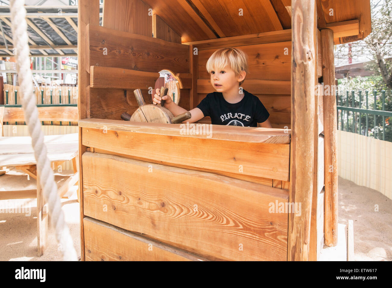 Kleiner Junge Lenkung Holzschiff auf Spielplatz Stockfoto