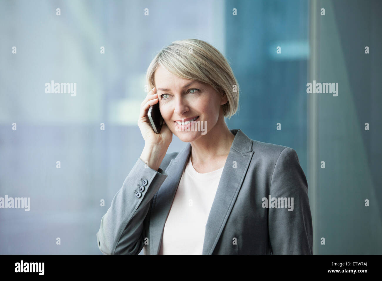 Geschäftsfrau, stehen am Fenster mit Handy Stockfoto