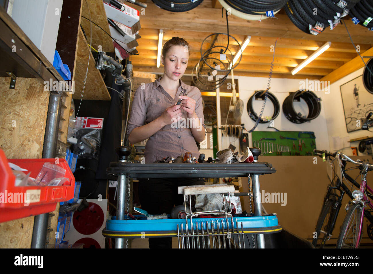 Junge Frau arbeitet in einer Fahrradwerkstatt Stockfoto