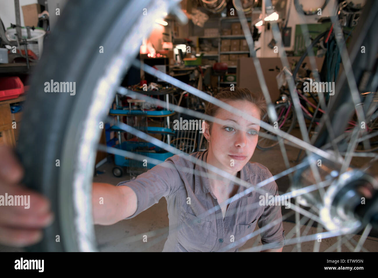 Junge Frau arbeitet in einer Fahrradwerkstatt Stockfoto