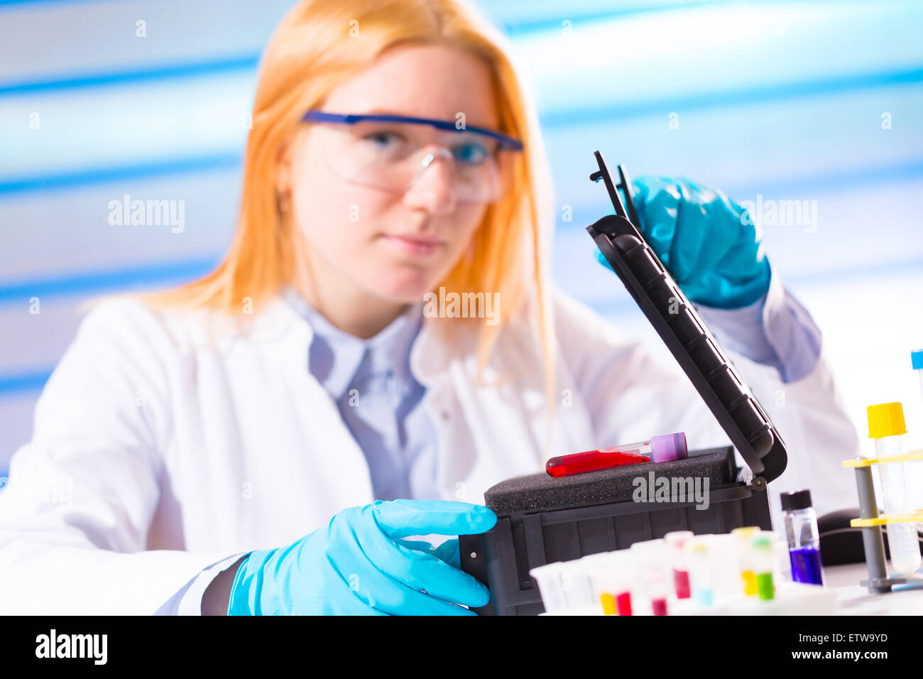 Flasche von Gefahrstoffen / Ebola-Virus / an den Händen eine Wissenschaftlerin Stockfoto