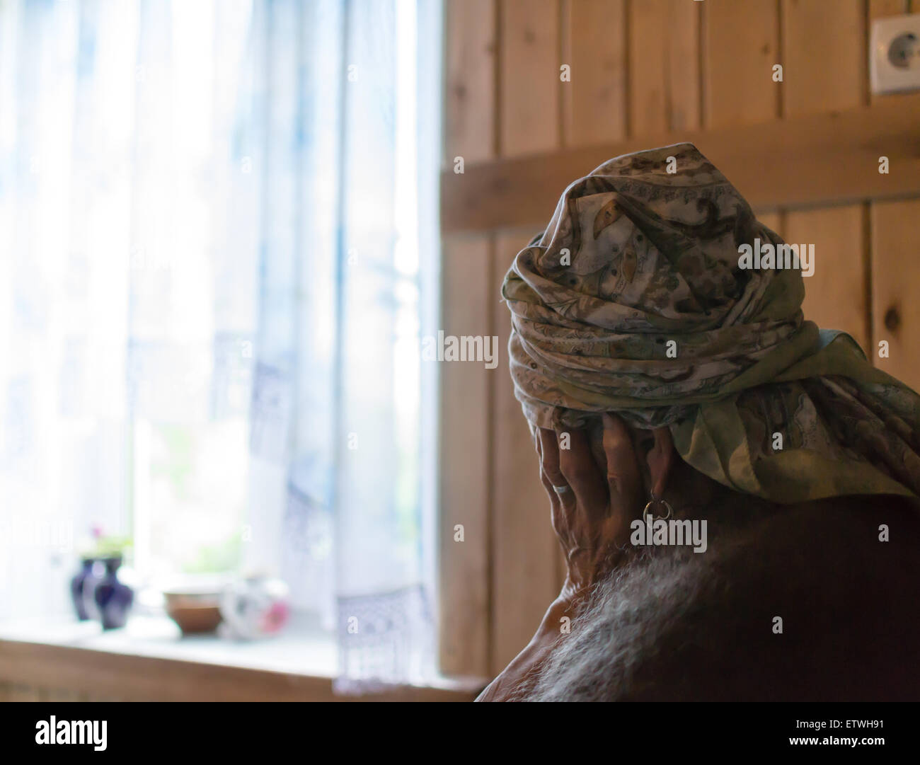 Einzelne alte Frau hält ihren Kopf mit einer einsamen Alter Hand Betrachtung Leben sitzen Stockfoto