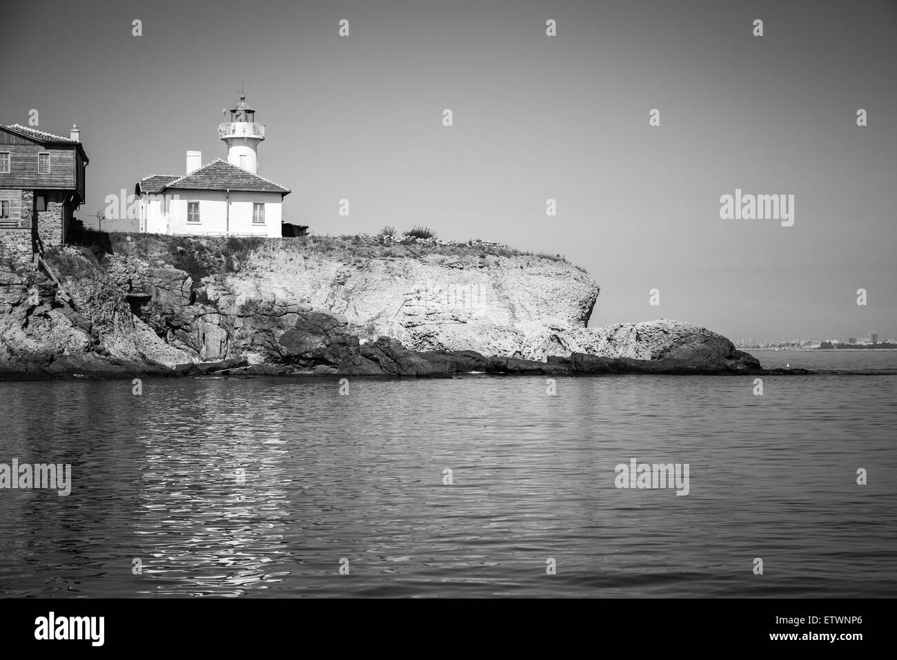 Weißer Leuchtturm und Holzbauten auf St. Anastasia Insel. Schwarzes Meer, Bulgarien. Monochrome Fotos Stockfoto