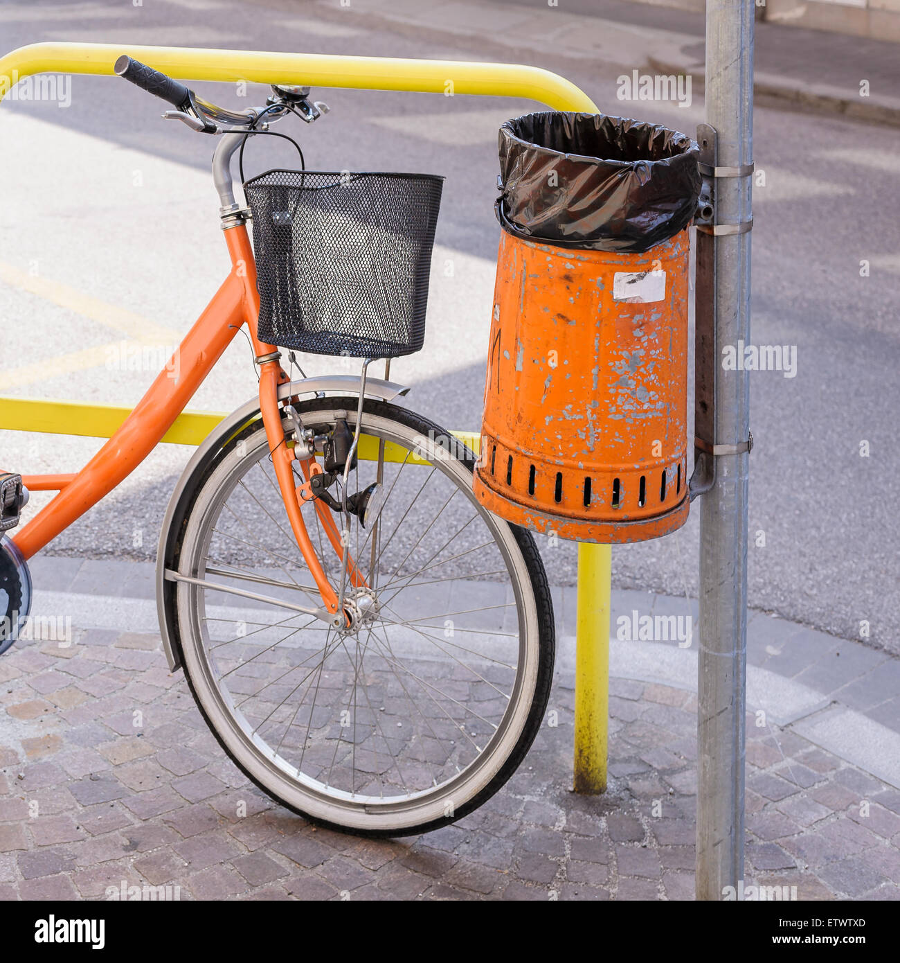 Papierkorb Metall orange Verschwendung von Straßen- und Fahrrad Stockfoto