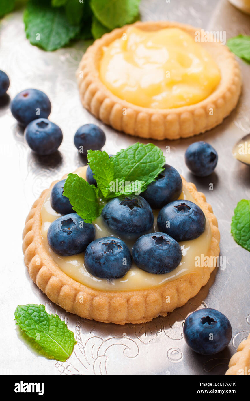 Verfahren zur Herstellung von Shortbread-Törtchen gefüllt mit Kalk-Quark und Heidelbeeren auf alten Vintage Metall-Hintergrund. Ferienkonzept. Stockfoto