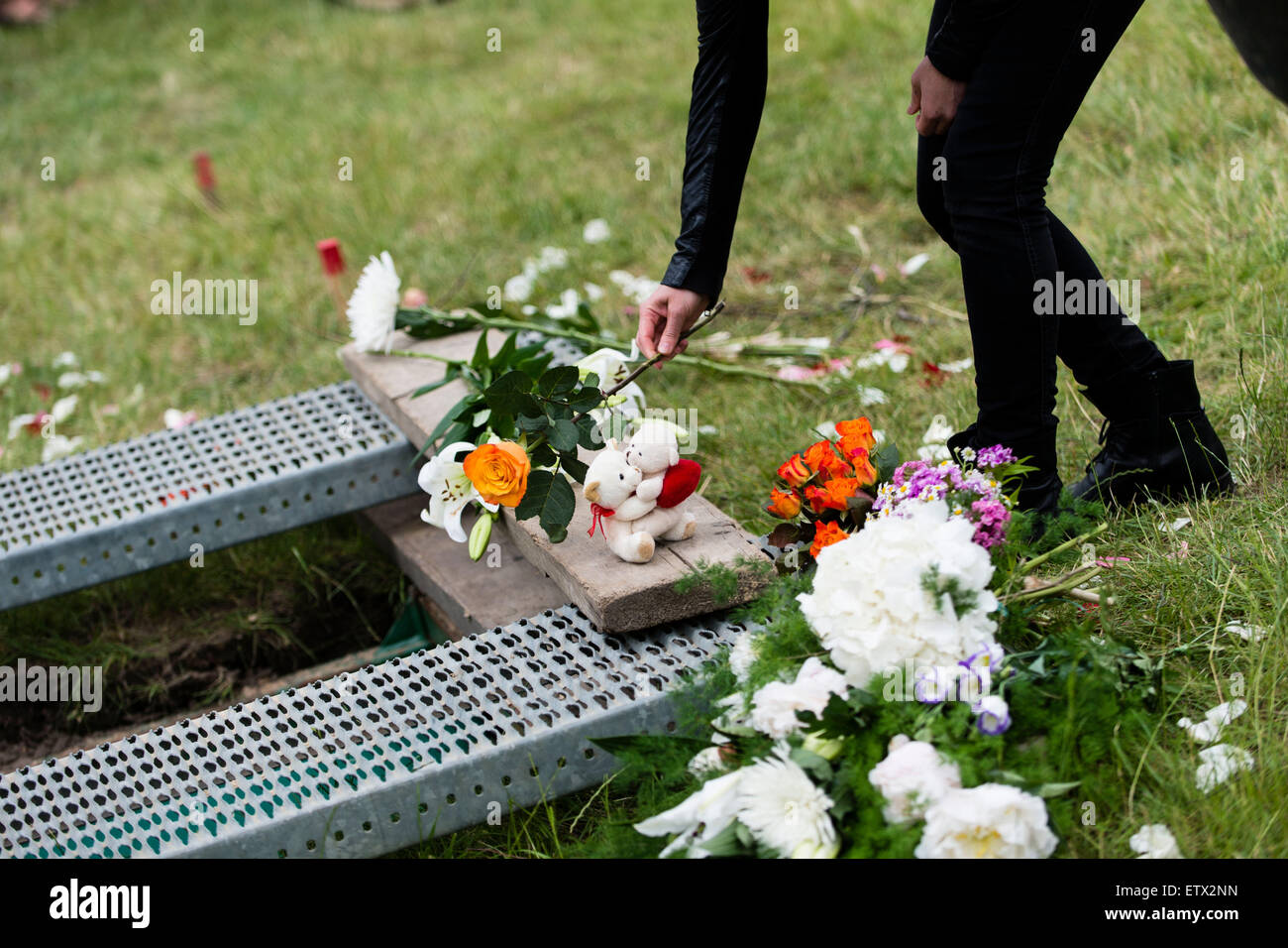 Trauernden legen Blumen auf das Grab einer Frau aus Syrien, die im Mittelmeer in der muslimischen Abschnitt des Friedhofs in Berlin, Deutschland, Berlin-Gatow 16. Juni 2015 ertrunken. Die Beerdigung ist eine Aktion von "Zentrum für politische Schönheit" Aktivisten gegen die EU Flüchtlingspolitik protestieren organisiert. Die Frau Hinterbliebenen, die in Deutschland leben und vereinbart, die Aktion waren nicht anwesend. Im Gegensatz zu den Aktivisten Erklärung wird die Frau Kind, die auch im Flug ertrunken, nicht mit ihr begraben werden. Nach Angaben von Aktivisten waren beide an Bord eines Schiffes, es Stockfoto