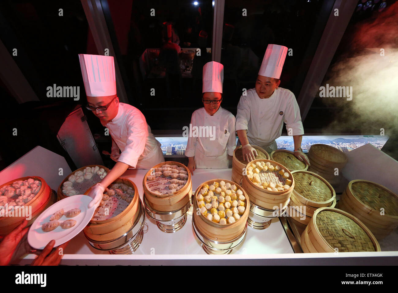 Hong Kong, China, Cook erreicht einem Gast einen Teller Dim sum Stockfoto
