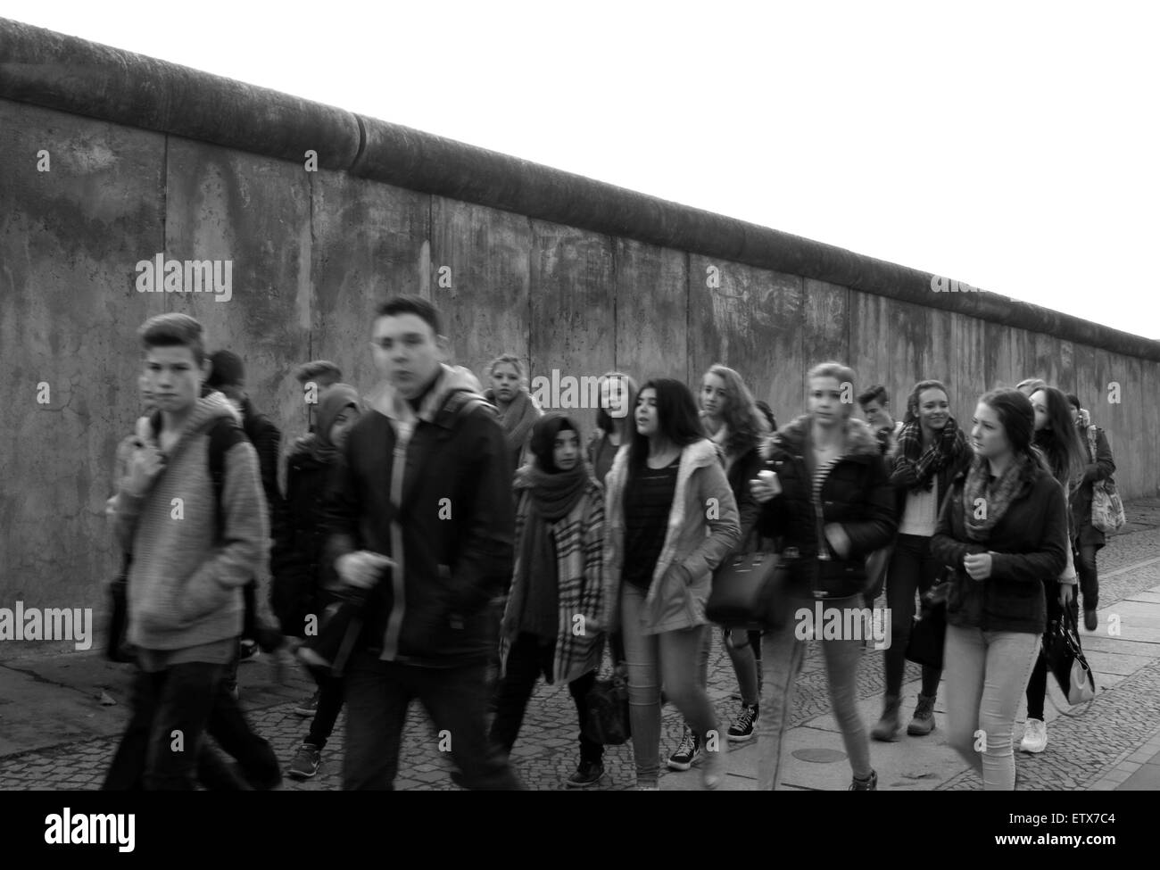 Berlin, Deutschland, ein Teil der ehemaligen Grenzmauer Jugendliche vorbeigehen. Stockfoto