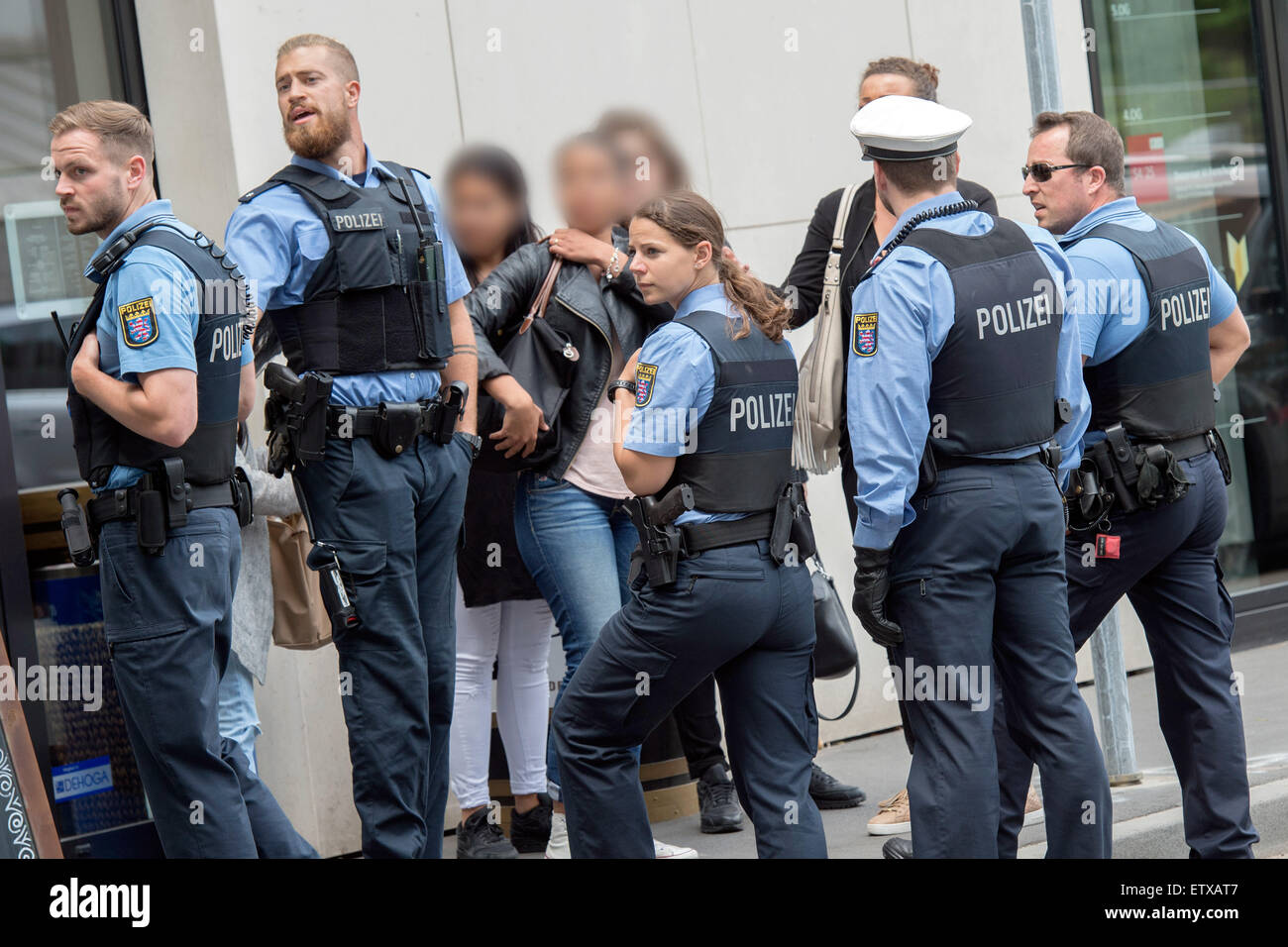 Darmstadt, Deutschland. 16. Juni 2015. Personen, die mit dem Beklagten Sanel M. sind durch eine Polizei nach einem Handgemenge vor dem Landgericht in Darmstadt, Deutschland, 16. Juni 2015 abgeschirmt. Das Gericht ist die Beklagte Sanel M. zu drei Jahren Haft für den gewaltsamen Tod des Schülers Tugce A. Verurteilung. Das Gericht erkannte juvenile Gesetz für Körperverletzung mit Todesfolge. Foto: BORIS ROESSLER/Dpa/Alamy Live News Stockfoto