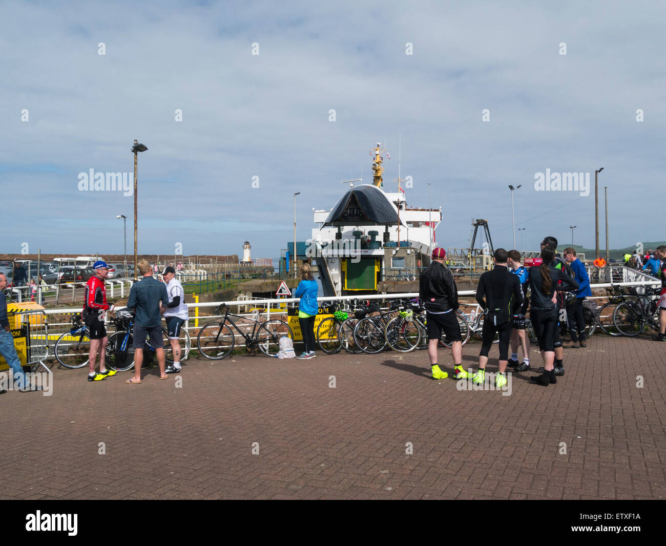 Männliche und weibliche Urlaub Radfahrer Schlange stehen am Ardrossan Ayrshire, Schottland Fähre Hafen für die Fähre nach Isle of Arran an einem schönen Maifeiertag Wetter blauen Himmel Stockfoto