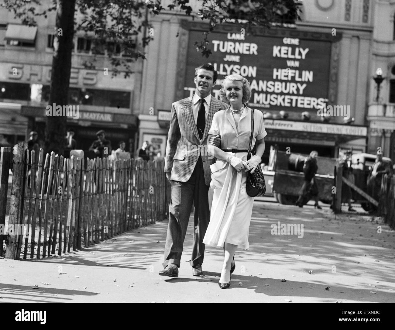 Angela Lansbury und Peter Shaw, abgebildet zu Fuß am Leicester Square in London 26. Juli 1949. Das Paar ist in London für ihre Trauung. Im Hintergrund, das Reich Kino, Förderung der Neuerscheinung die drei Musketiere, Darsteller, Lana Turner, Gene Kelly, June Allyson, Van Heflin und Angela Lansbury. Stockfoto