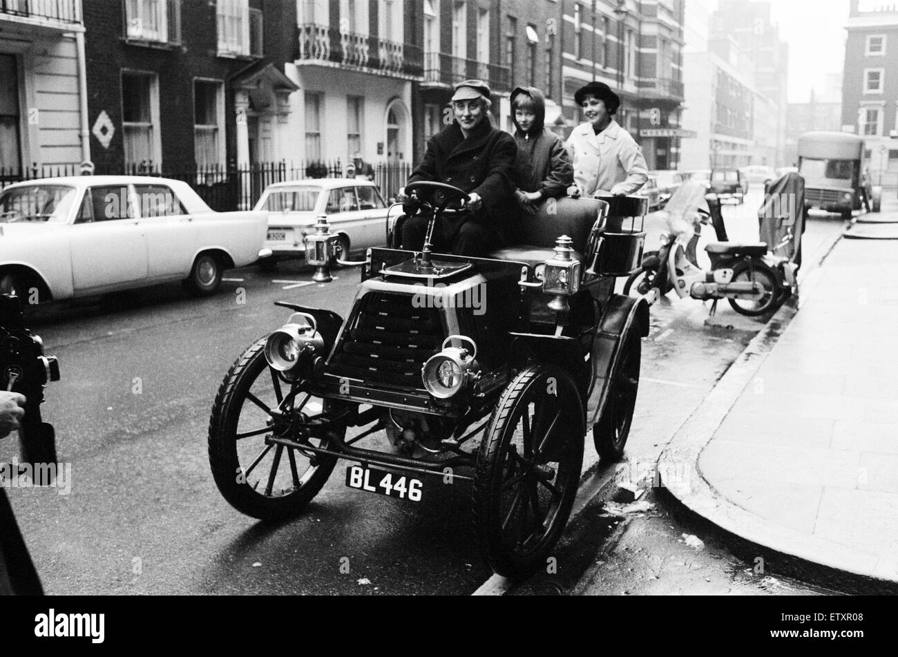 Spike Milligan aus für eine Fahrt im Regen in einem 1901 Durkopp ausgeliehen von Montague Motor Museum. Spike wird fahren es in London, Brighton Veteran Auto laufen. Mit ihm auf einen Probelauf sind seine 10 jährige Tochter Sile (links) und ihre Freundin Zosia. Stockfoto