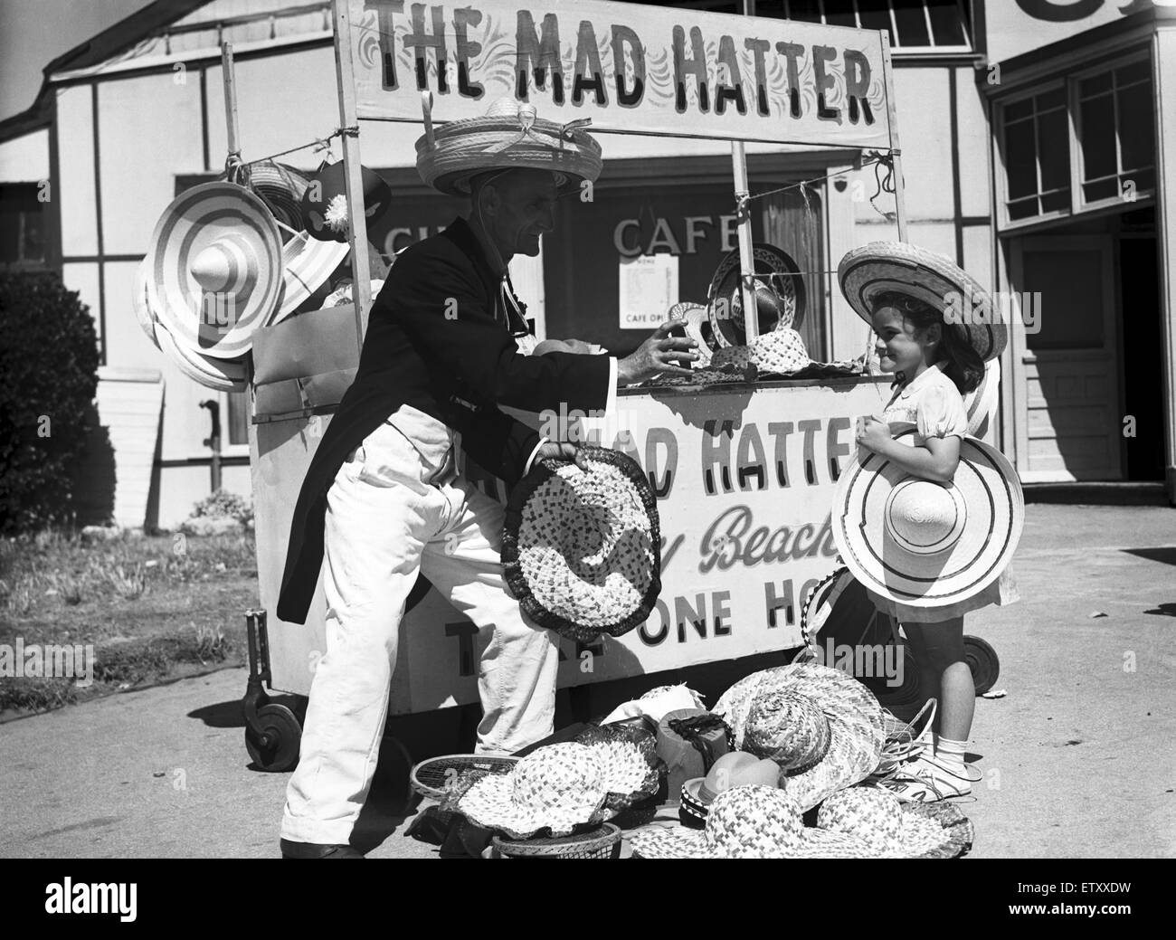 Ein junges Mädchen, die versuchen, auf einen Hut an "The Mad Hatter" Stand, in Barry Island, Vale of Glamorgan, Wales. 5. August 1951. Stockfoto