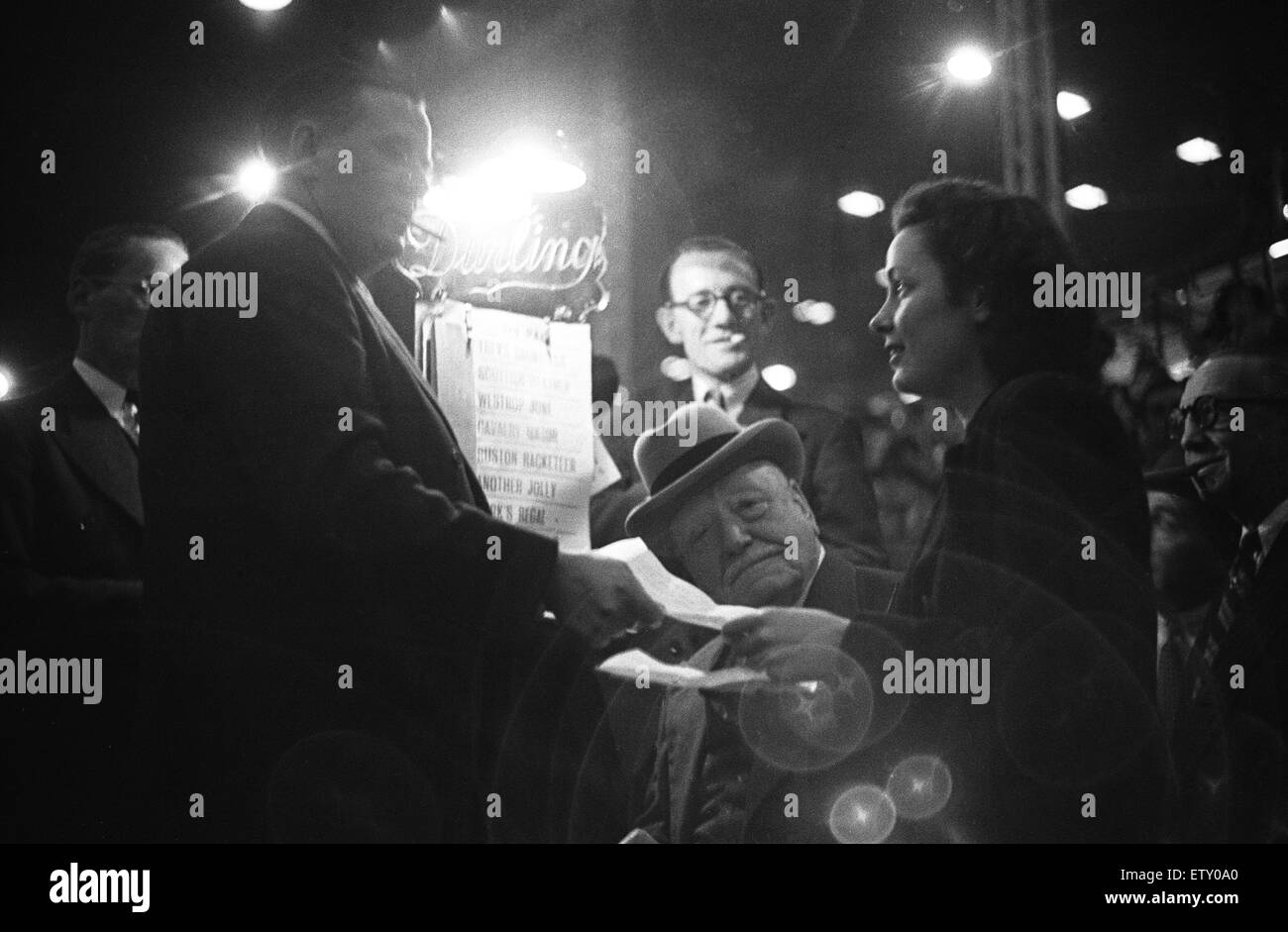 Eine junge Rasse Theatermenüs setzt eine Wette in einer Nacht in der Hunde, White City Greyhound Track. 7. September 1946 Stockfoto