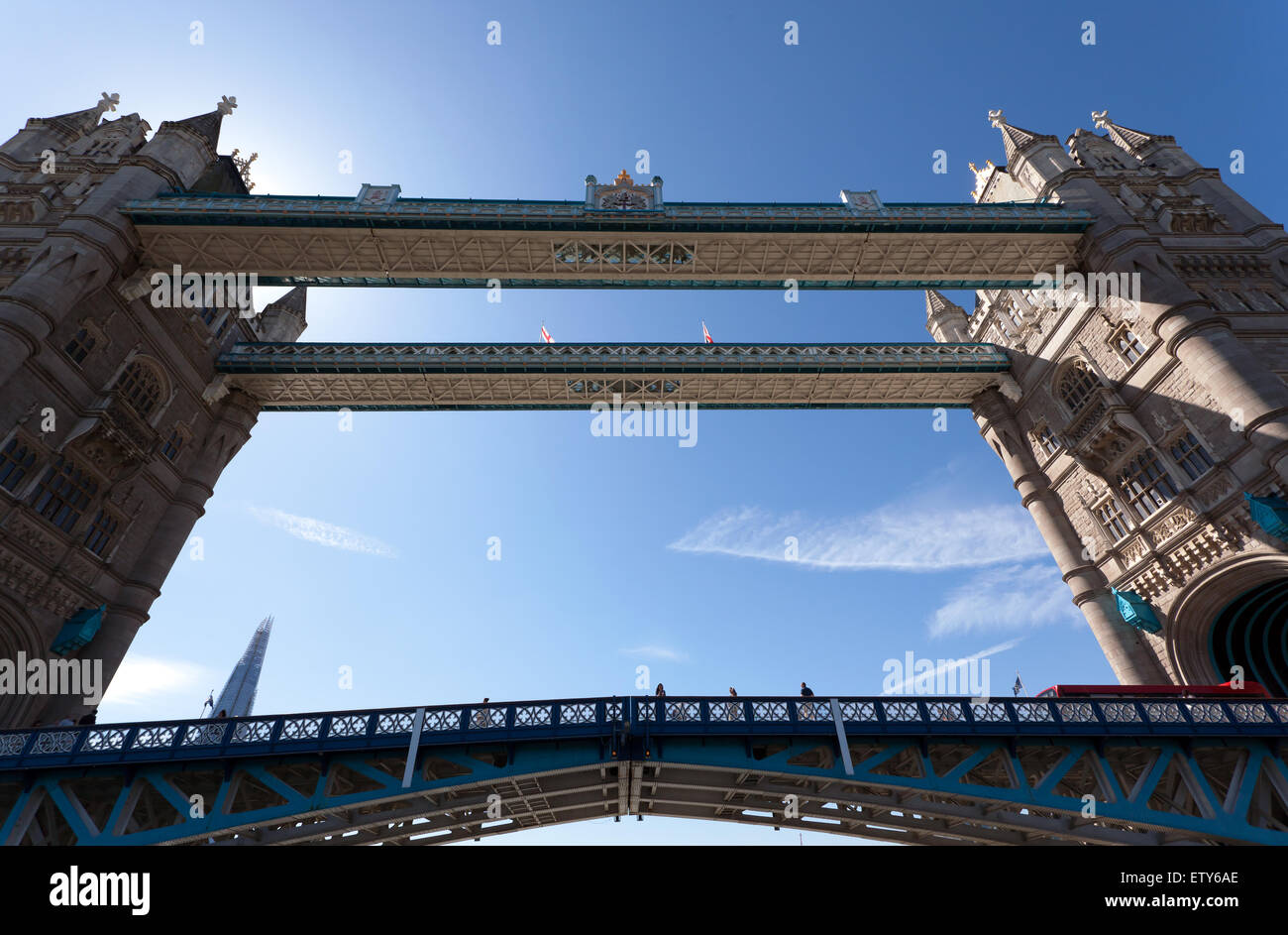 Ein Blick nach oben auf den Gehwegen der Tower Bridge, bestandener nur dahinter in einem Thames Clipper. Stockfoto
