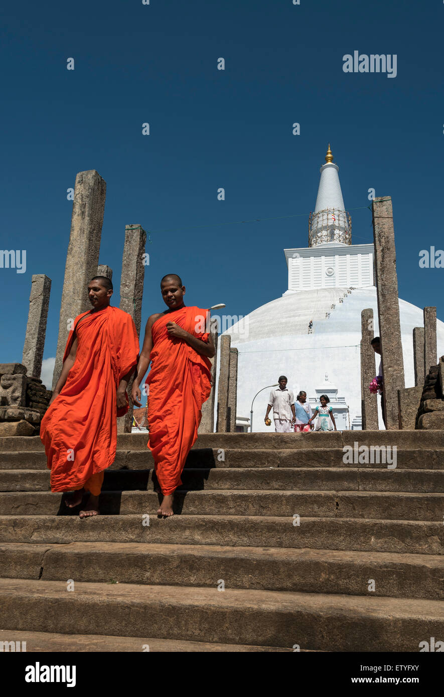 Buddhistische Mönche in Safran Roben außerhalb Ruwanwelisaya (Ruwanweli Maha Seya) Stupa, Anuradhapura, Sri Lanka Stockfoto