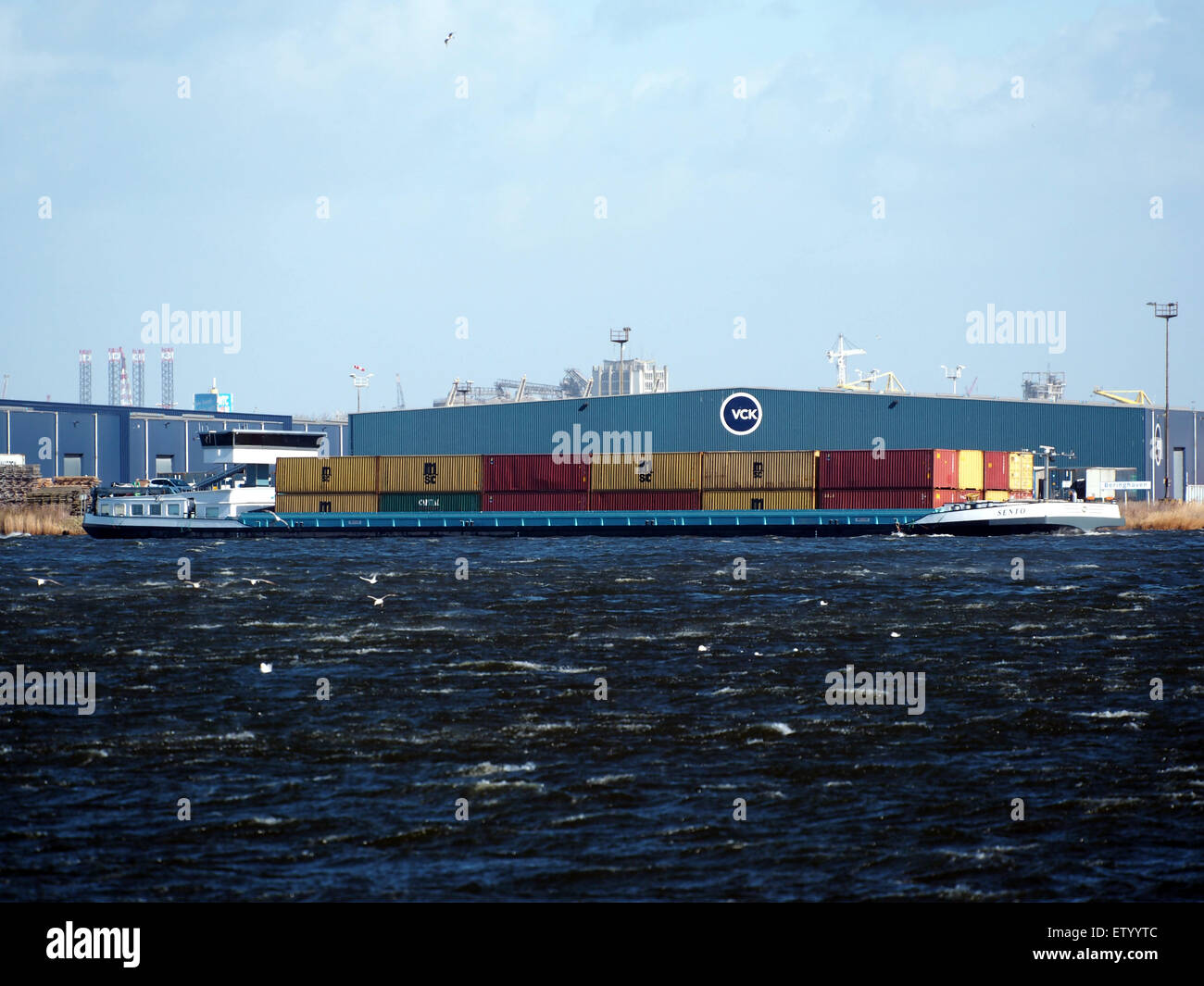 Eine Szene aus dem Hafen von Amsterdam, die verschiedene Schiffe zeigt, darunter Öltanker, Containerschiffe, Binnenschiffe und Schlepper. Der geschäftige Hafen ist ein wichtiger Drehkreuz für den internationalen Handel und den Transport von Waren über Ozeane und Flüsse. Stockfoto